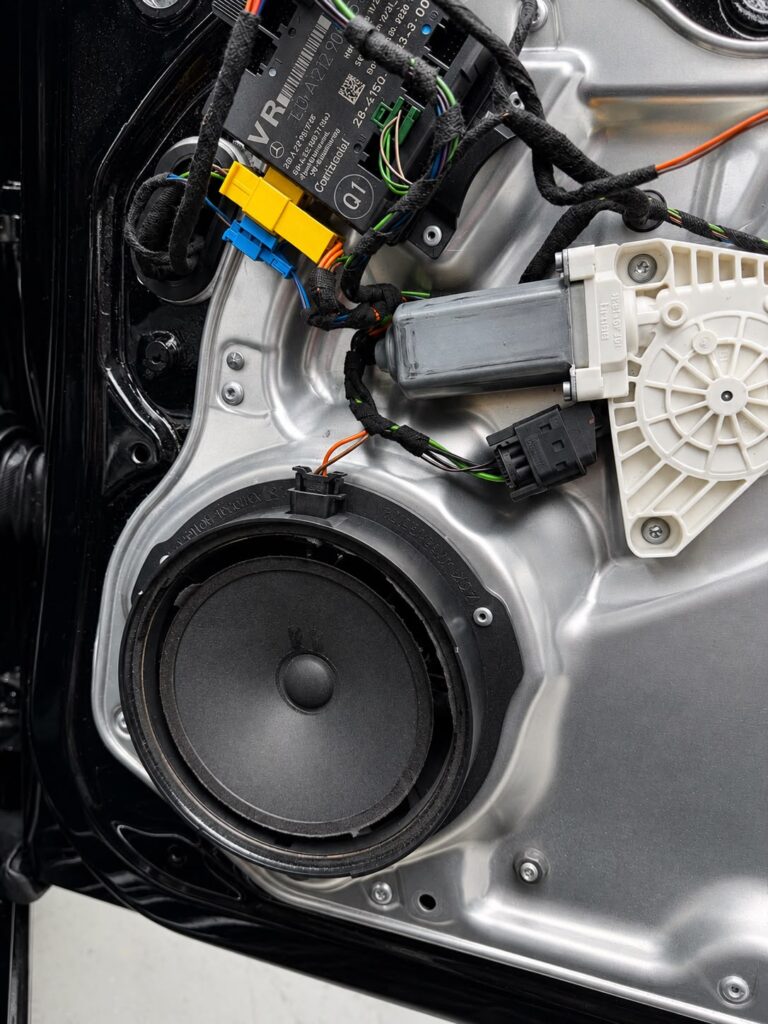 Torn original Mercedes E-Class W212 door speaker cone before replacement in Dubai
