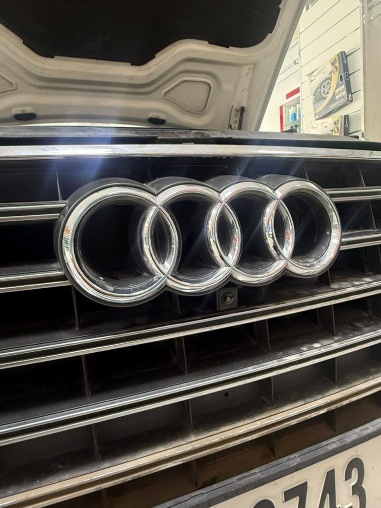 Front camera installed behind the Audi rings grille on a 2012 Audi A8 at Weiss Auto Concept Dubai