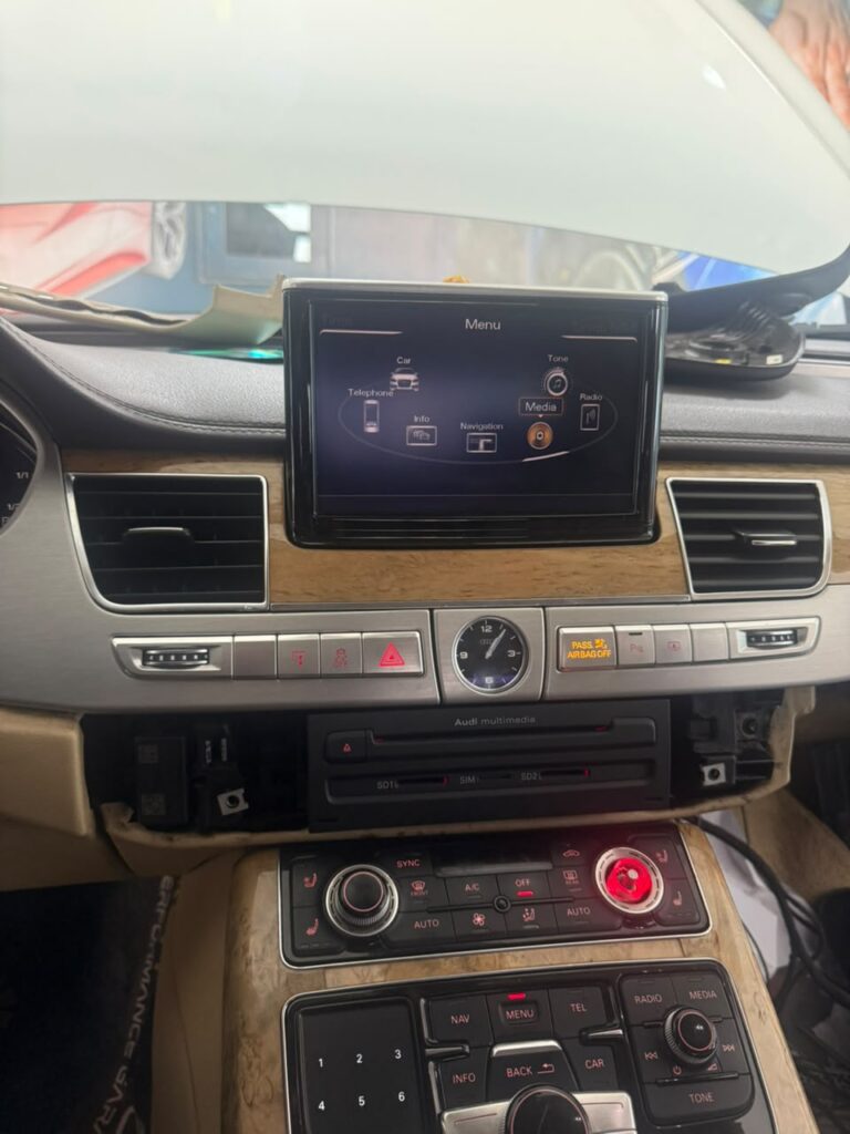 Audi A8 factory MMI 3G main menu on the retractable dashboard screen at Weiss Auto Concept Dubai