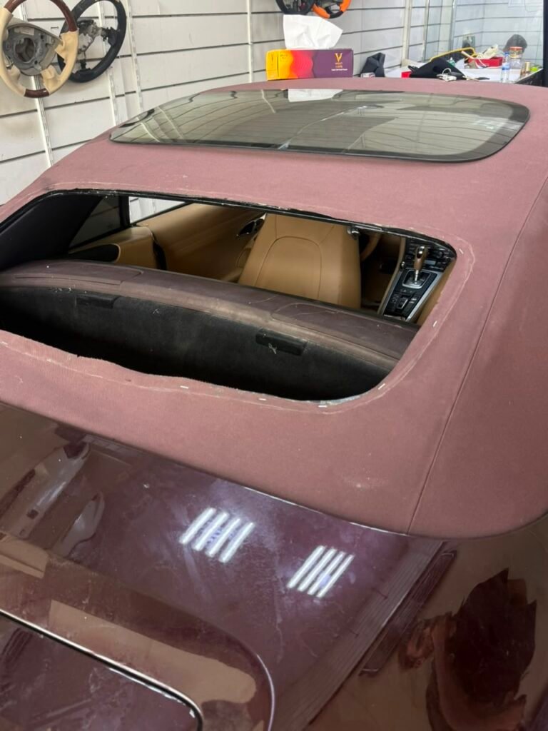 Porsche 911 soft top with rear glass being aligned during installation in Dubai