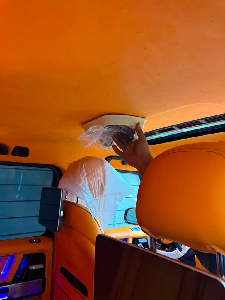 Test-fitting a roof instrument cluster shell against the sunroof frame of a Mercedes-AMG G63 in Dubai