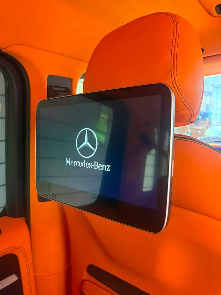OEM Mercedes headrest monitor installed in a 2022 Mercedes-AMG G63 with orange leather interior in Dubai