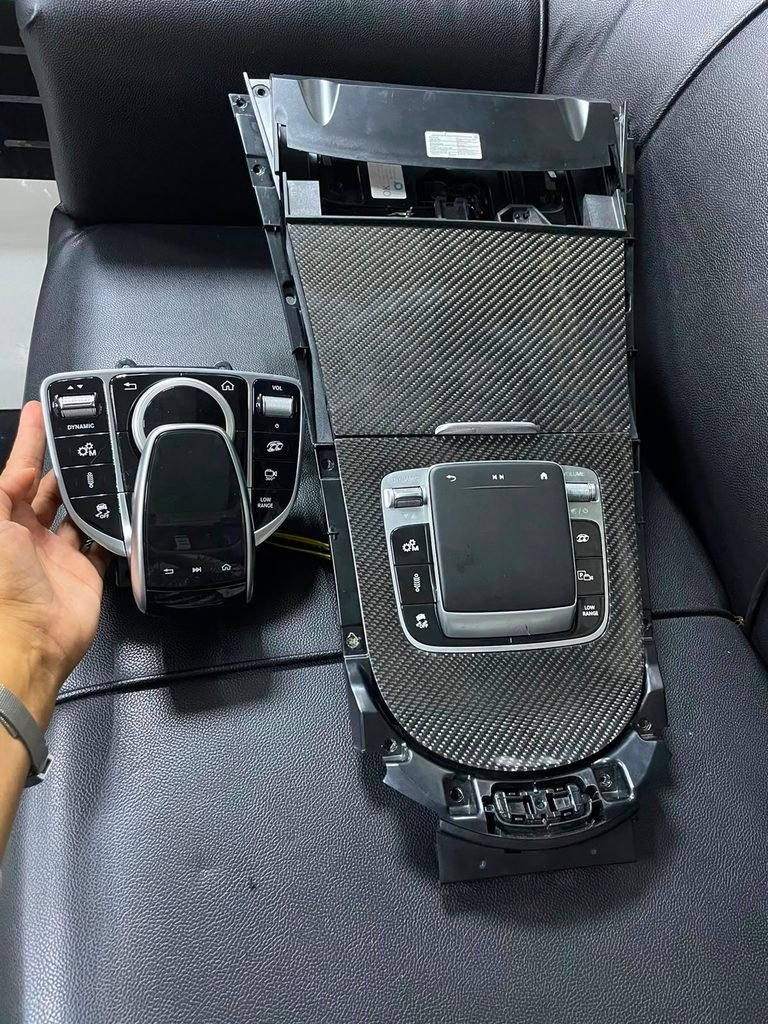 Original W463A rotary controller next to a W465-style carbon touchpad panel for a Mercedes-AMG G63 in Dubai